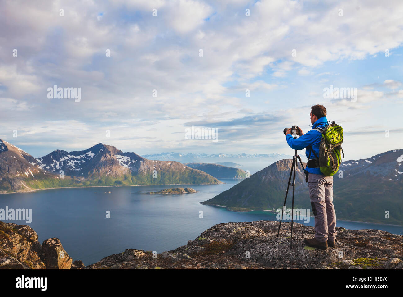 Landschaftsfotografen arbeiten mit Stativ und Dslr-Kamera in wilder Natur, stehend mit Rucksack auf Berg Stockfoto