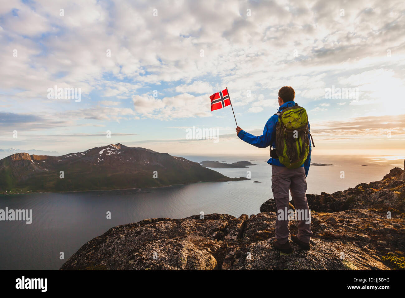 Wandern in Norwegen, Silhouette der Wanderer Blick auf schöne Fjordlandschaft und Holding norwegische Flagge, Abenteuer im freien Stockfoto