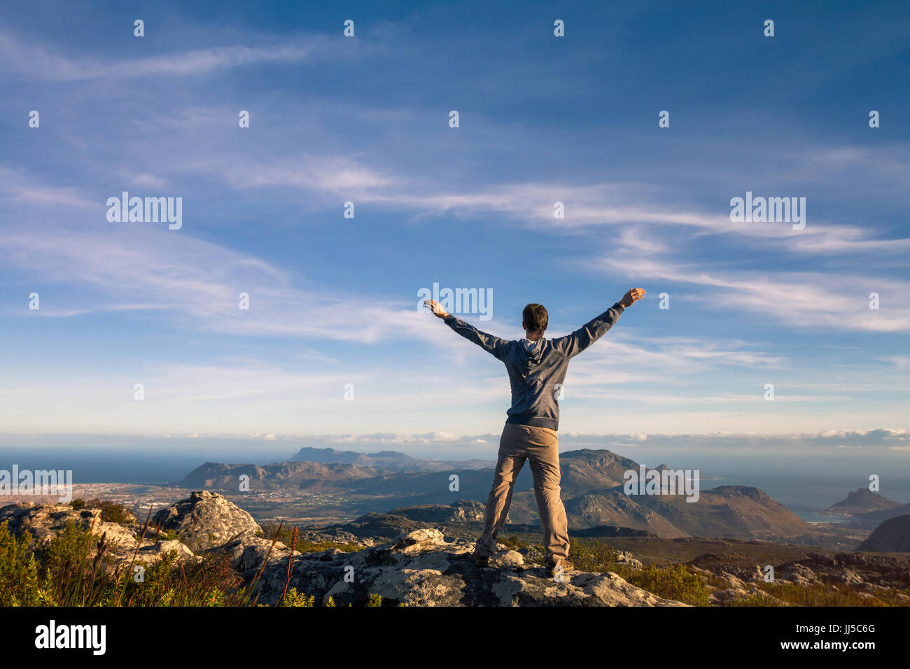 Mann stand mit erhobenen Händen auf den Tafelberg in Kapstadt, Südafrika Stockfoto