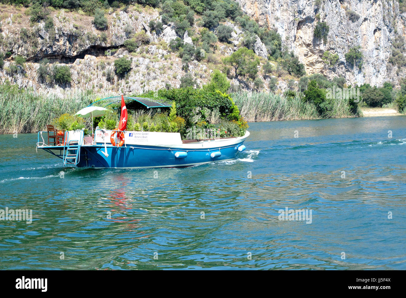Ein Ausflugsschiff gefüllt mit Blumen und Sträuchern auf dem Fluss Cari vom Fluss Dorf Dalyan, ein beliebter Urlaubsort in der Türkei Stockfoto