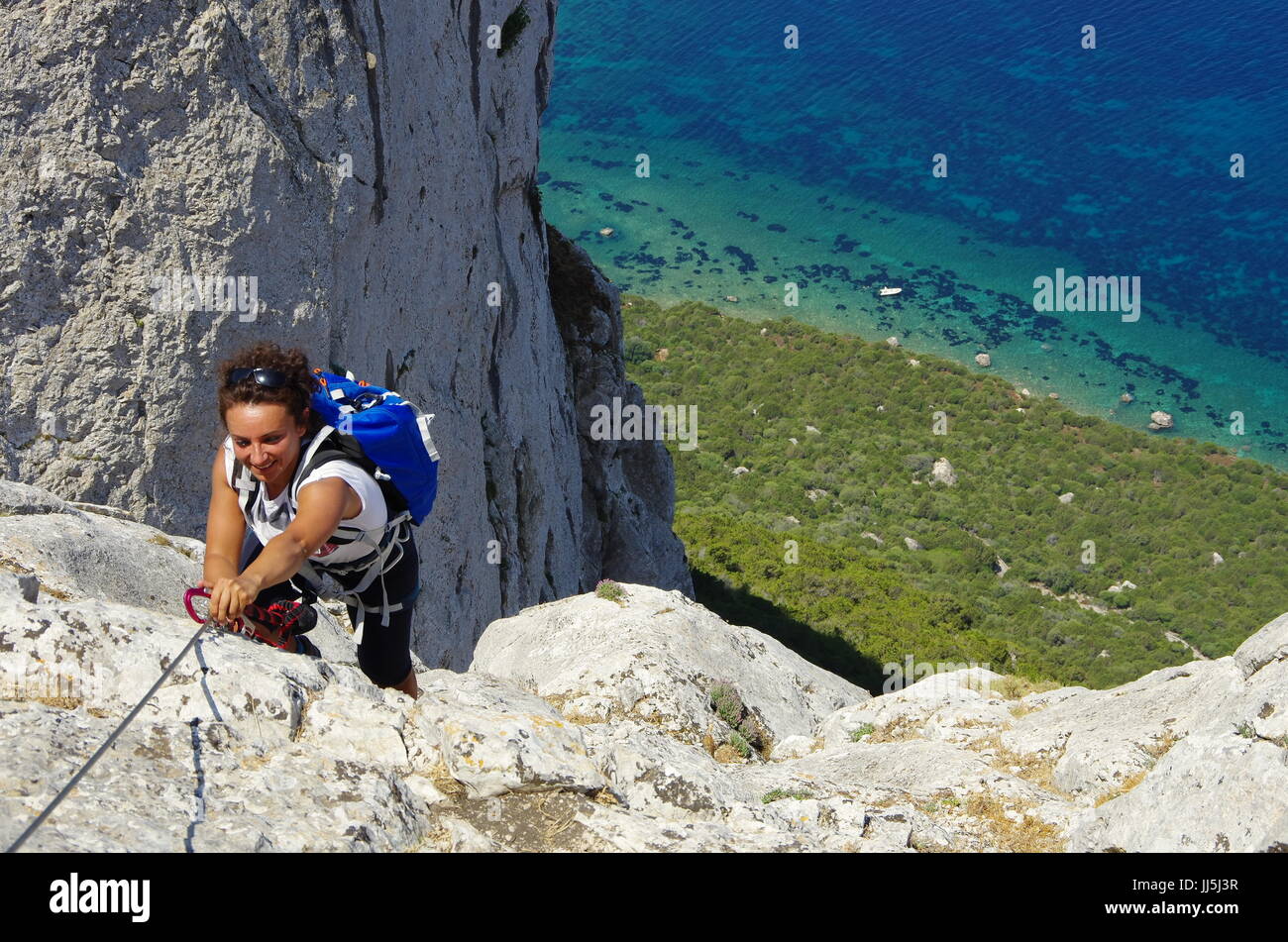 Weibliche Wanderer (junge Erwachsene) auf dem Weg zum Gipfel des Tavolara, Lookng hinunter in Richtung Meer. Stockfoto