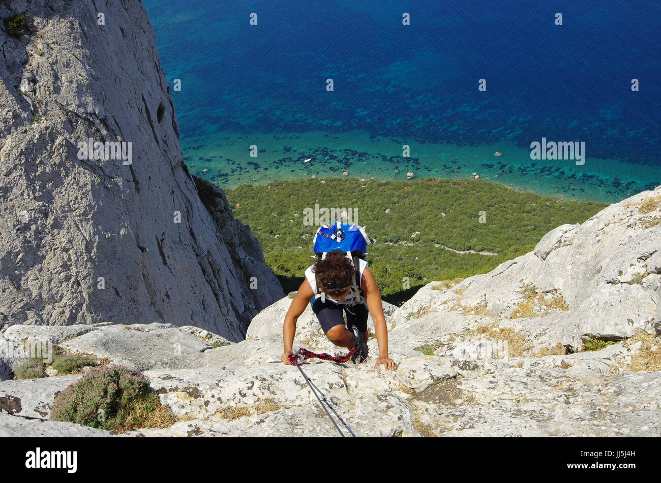 Weibliche Wanderer (junge Erwachsene) auf dem Weg zum Gipfel des Tavolara, Lookng hinunter in Richtung Meer. Stockfoto