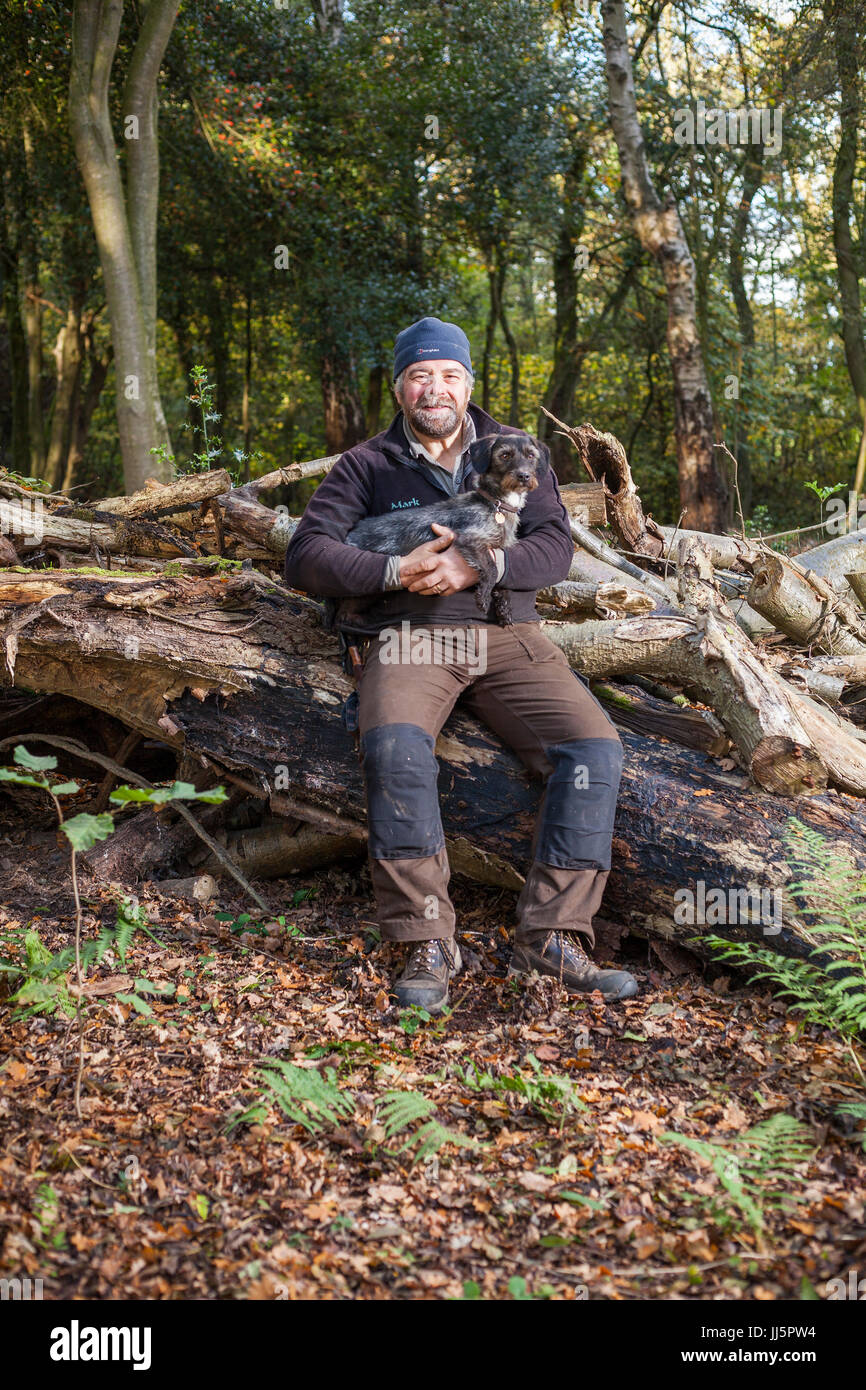 Mark Eccleston und seinem Hund Bertie. Er ist ein ehemaliger Bahnhof Fahrdienstleiter, die sieben Hektar aufgearbeiteten Wald in Telford, Shropshire mietet. Vereinigtes Königreich Stockfoto