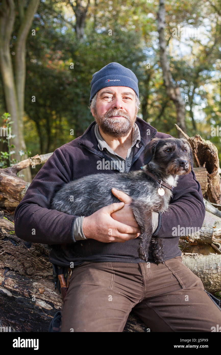 Mark Eccleston und seinem Hund Bertie. Er ist ein ehemaliger Bahnhof Fahrdienstleiter, die sieben Hektar aufgearbeiteten Wald in Telford, Shropshire mietet. Vereinigtes Königreich Stockfoto