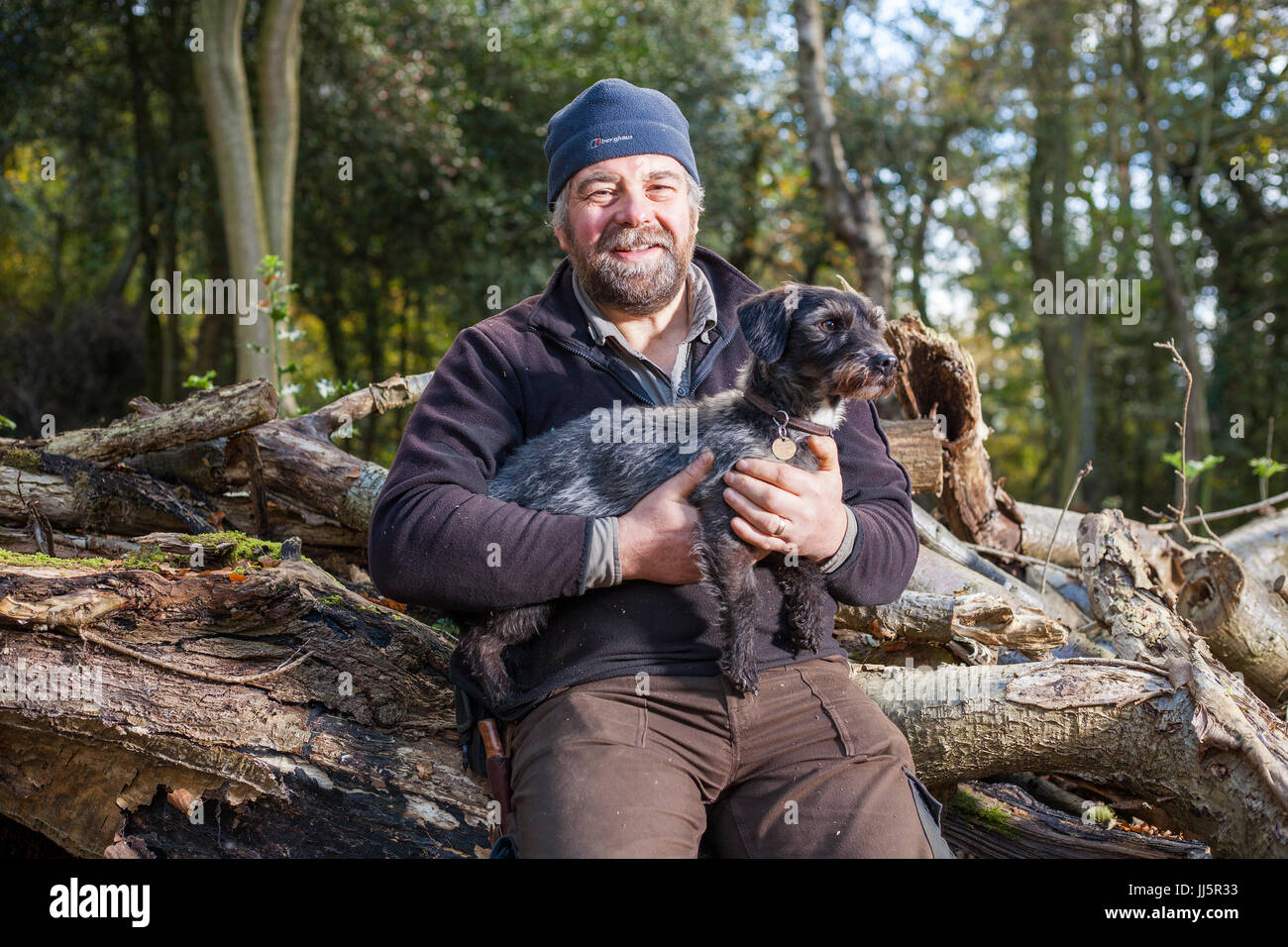 Mark Eccleston und seinem Hund Bertie. Er ist ein ehemaliger Bahnhof Fahrdienstleiter, die sieben Hektar aufgearbeiteten Wald in Telford, Shropshire mietet. Vereinigtes Königreich Stockfoto