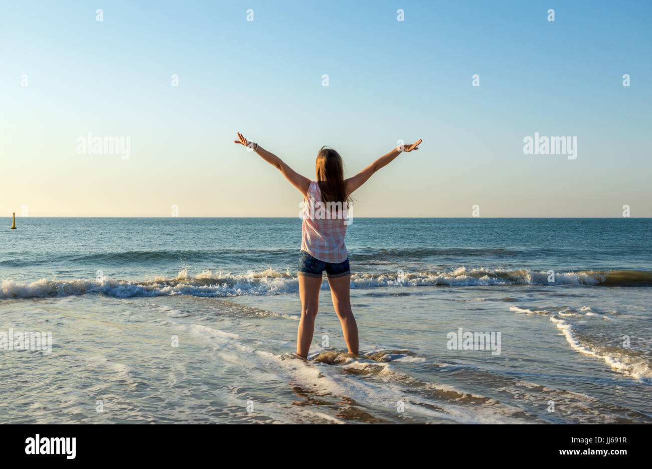 Glückliche junge Frau genießt Sommer und Meer im Abendlicht. Ferien-, Reise- und Freiheit Konzept Stockfoto