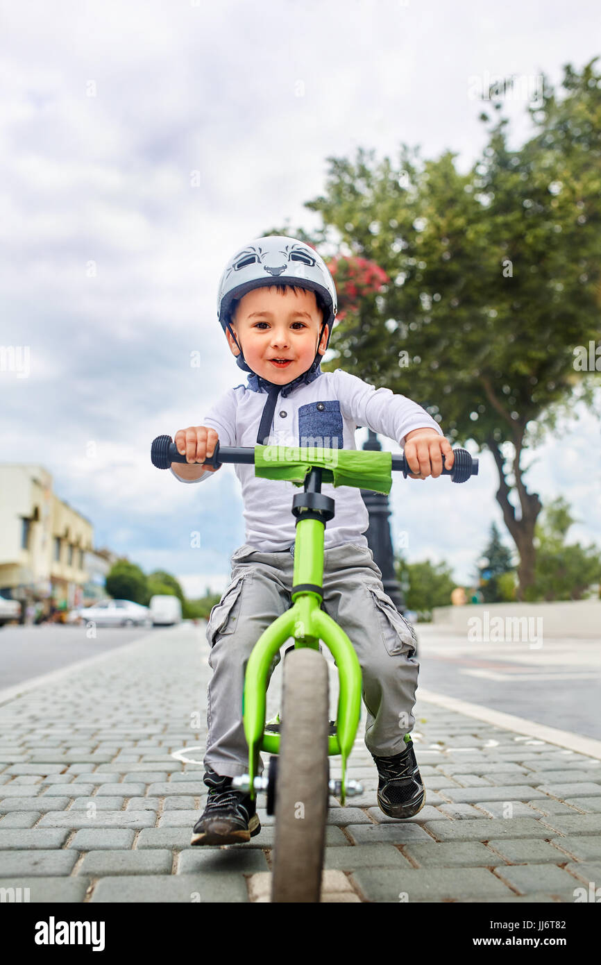 Junge Zicklein in Helm Fahrrad im Stadtpark. Fröhliches Kind im Freien. Stockfoto