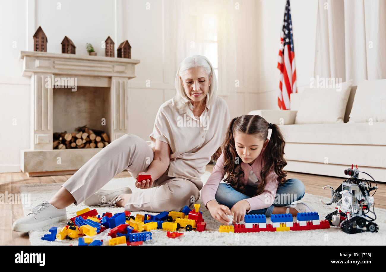 Attraktive ältere Frau sitzt in der Nähe von ihrer Enkelin Stockfoto