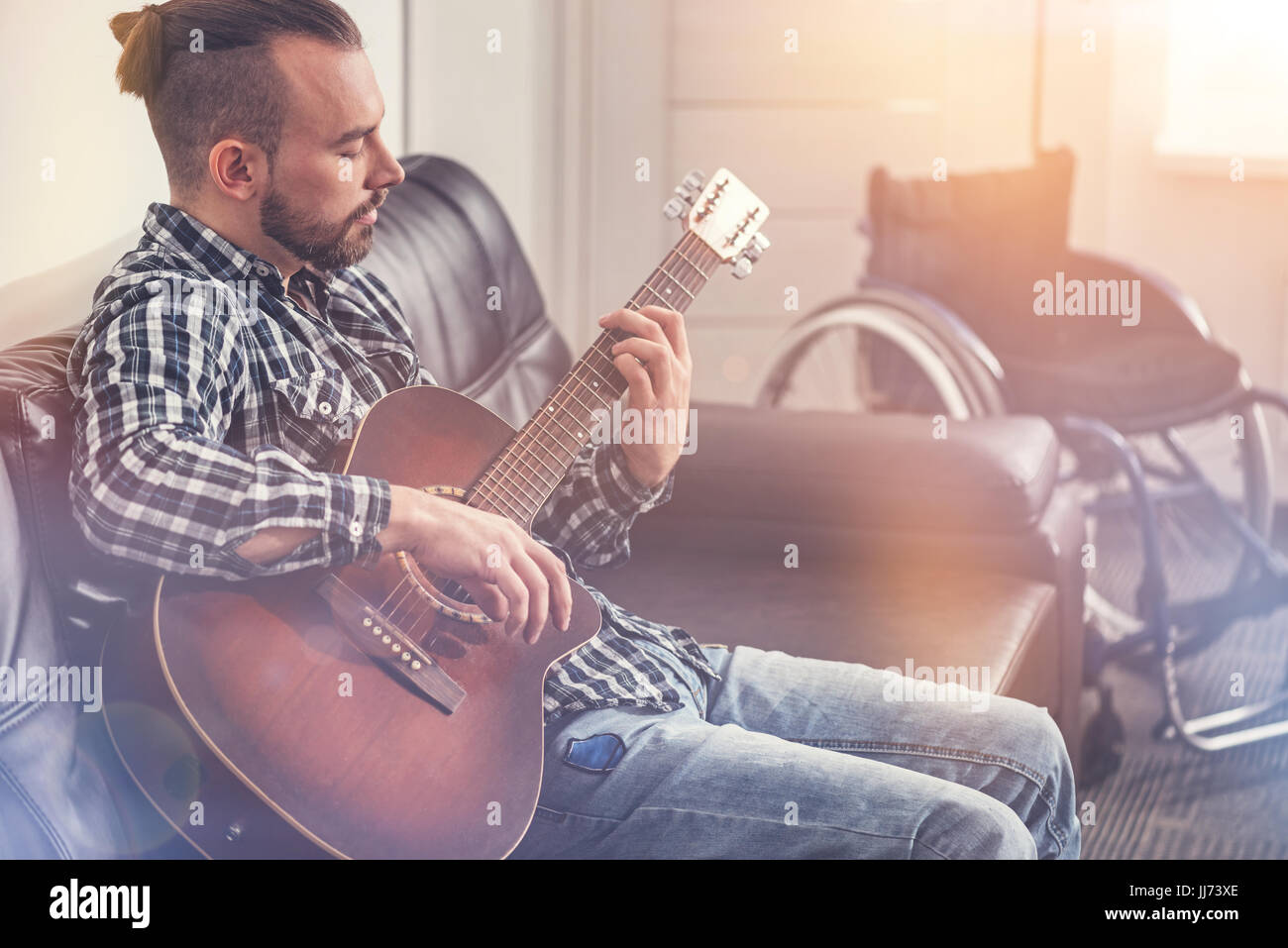 Raetselhaften junger Mann, die Gitarre zu spielen Stockfoto