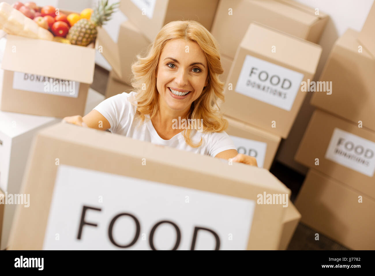 Bewundernswerte großzügige Dame mit einer Kiste voller Spenden Stockfoto