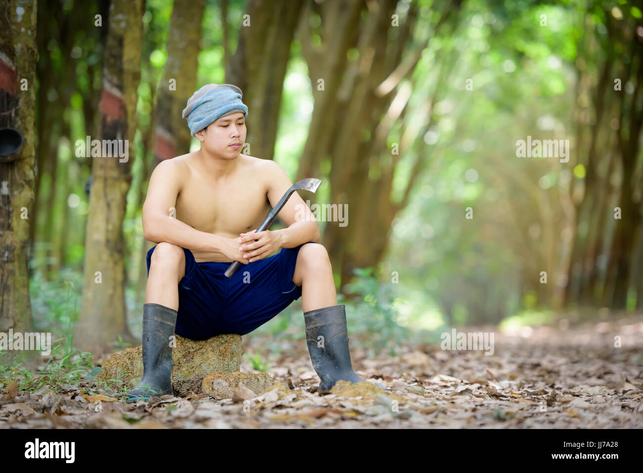 Deprimiert Mann mit Kautschuk-Plantage Bauern aus niedrigen Preisen. Stockfoto