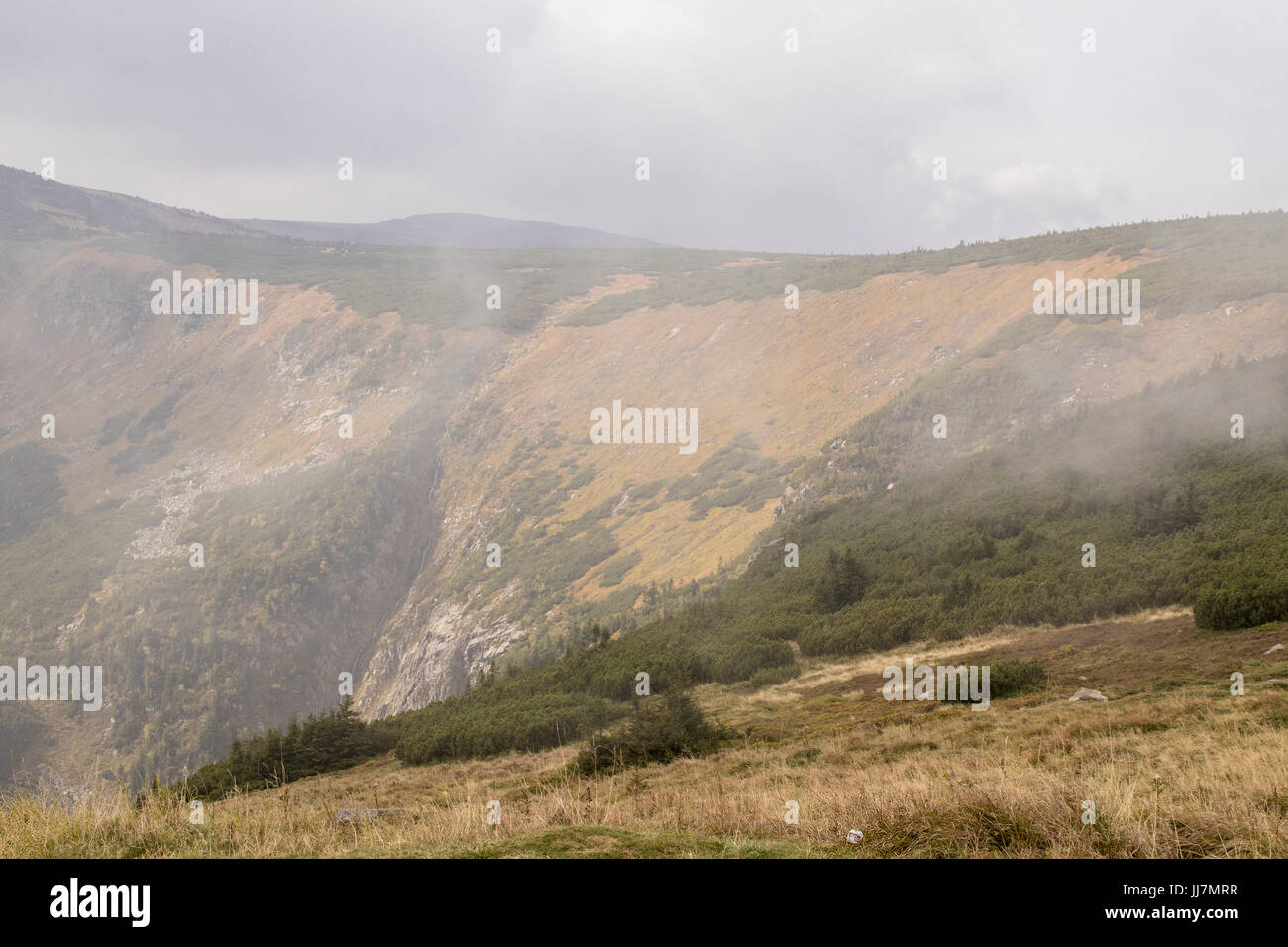 Herbst Berg Lansdcape in bedecktem steilen Hügel mit nebligen Hintergrund entnommen Stockfoto