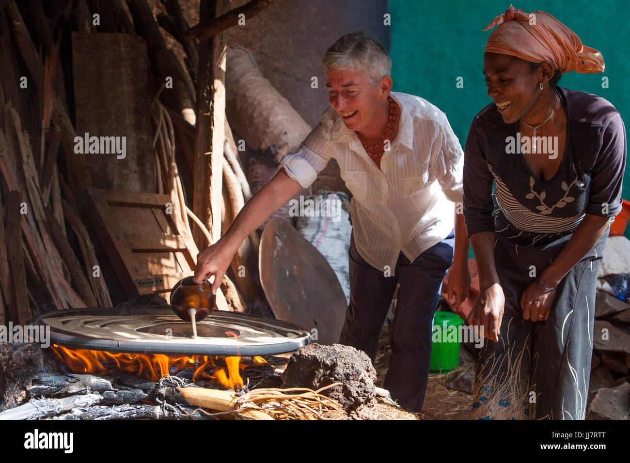 Ein freiwilliger Injera mit ihrem äthiopischen Gegenstück und Freund kochen lernen. Stockfoto