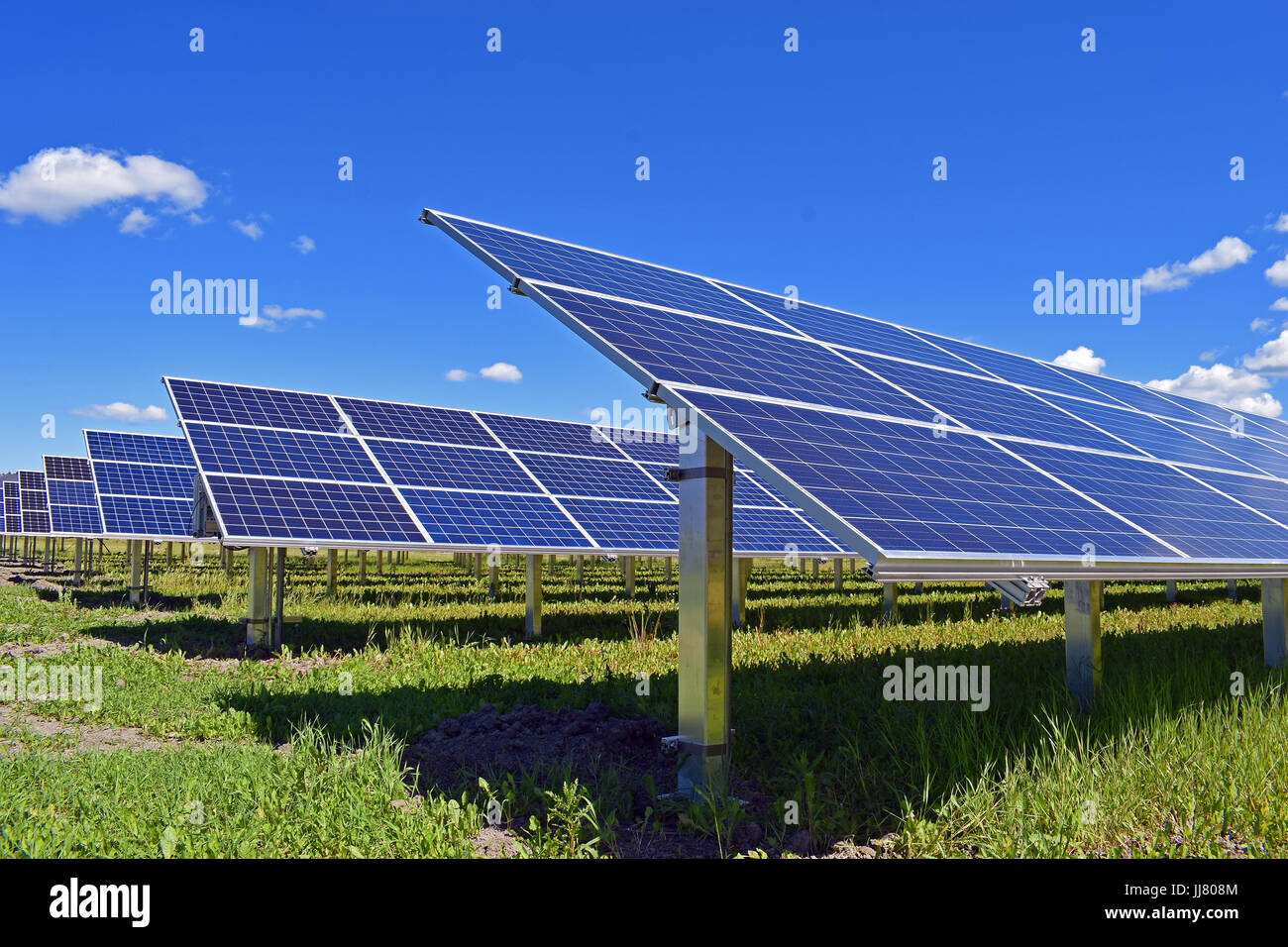 Sonnenkollektoren auf Feld. Klaren Himmel mit ein paar kleine Wolken im Hintergrund. Stockfoto