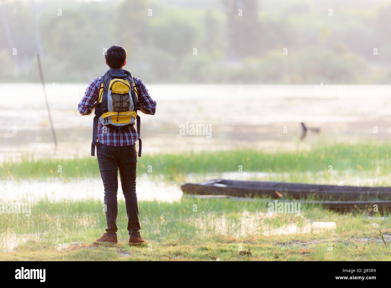 Männliche Backpacker Touristen stehen am Fluss und beobachten den Sonnenuntergang. Stockfoto