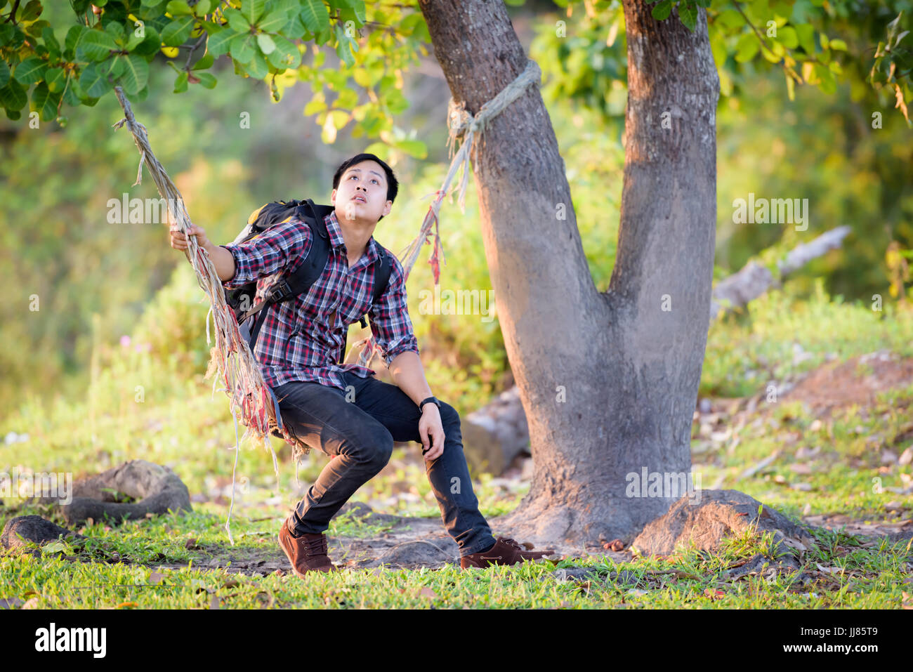 Touristen fahren auf einer Hängematte unter einem Baum. Stockfoto