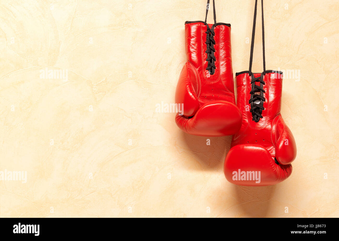 Roten Boxhandschuhe von Schnürsenkel an Wand hängen Stockfoto