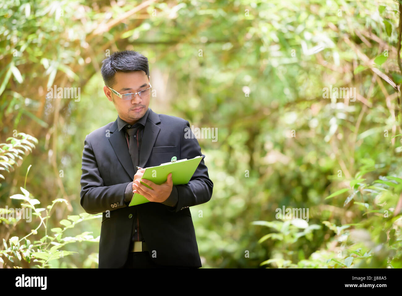 Pflanzenforscher überprüfen das Papier in einem Wald. Stockfoto