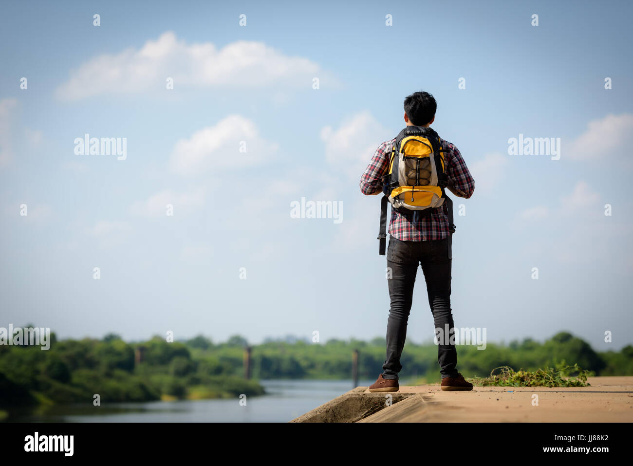 Ein asiatische Touristen Mann mit Backpacker ist den Fluss beobachten. Urlaub und Natur Konzepte. Stockfoto