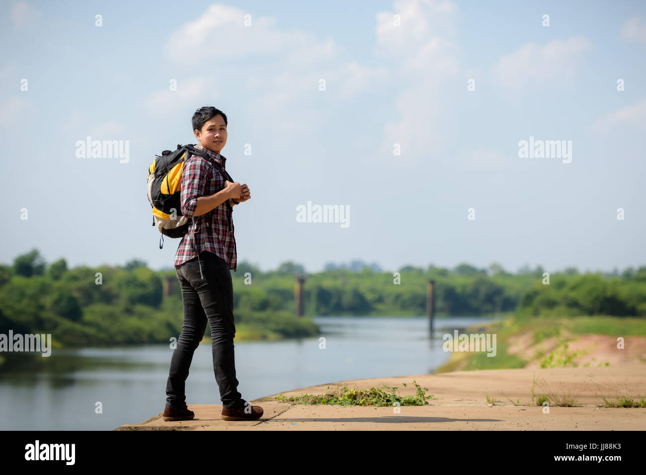 Eine asiatische Touristen Mann Rucksack einen Fluss zu genießen. Urlaub und Natur Konzepte. Stockfoto