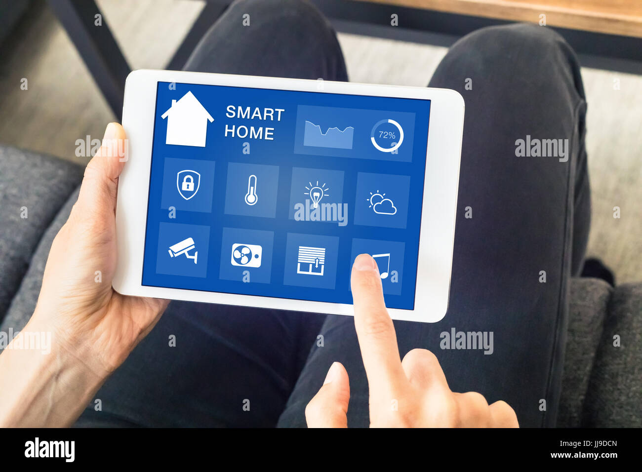 Nahaufnahme der Hände mit smart home-Automation-Assistent auf einem digitalen Tablet-Computer-Bildschirm zu kontrollieren angeschlossen Geräte im Zimmer Stockfoto