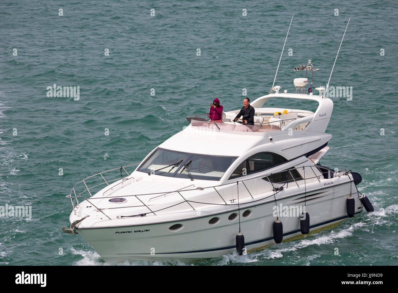 Paar auf Fairline phantom 46 Bootfahren im Solent zwischen Lymington und Yarmouth, Isle Of Wight, Hampshire, UK im Juli Stockfoto