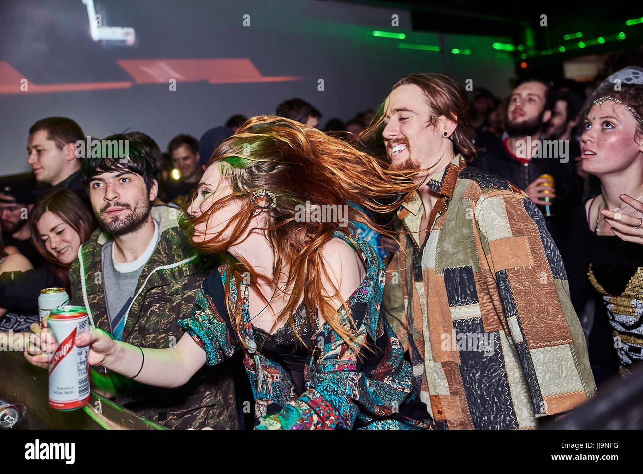 BRISTOL, UK - Dezember 2016: Eine junge, attraktive Frau Haare bedeckt teilweise ihr Gesicht als sie in einer Menschenmenge in einem Nachtclub am 4. Dezember 2016 tanzt Stockfoto