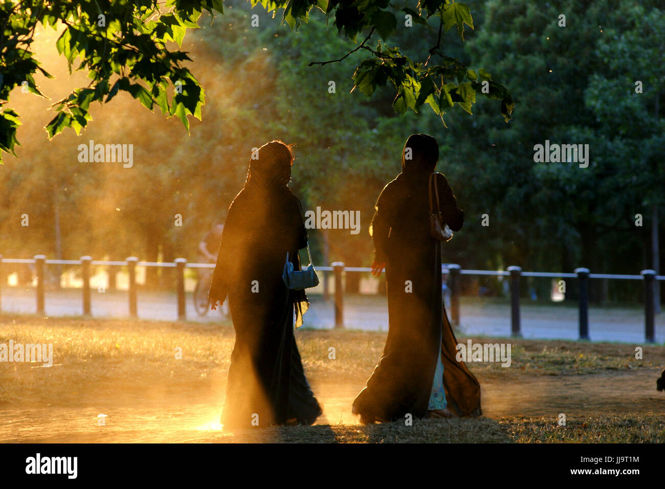 Fotografieren von zwei Frauen, die zu Fuß in Hyde Park, London, England, UK Stockfoto