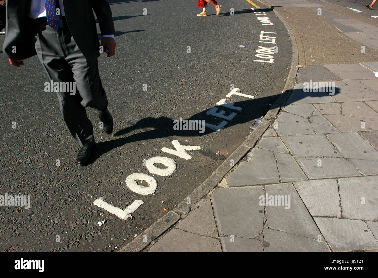 Wörter suchen links auf der Straße warnen Fußgänger, die möglicherweise nicht vertraut mit British Traffic-Muster wie Sie sicher in London, England, UK Stockfoto