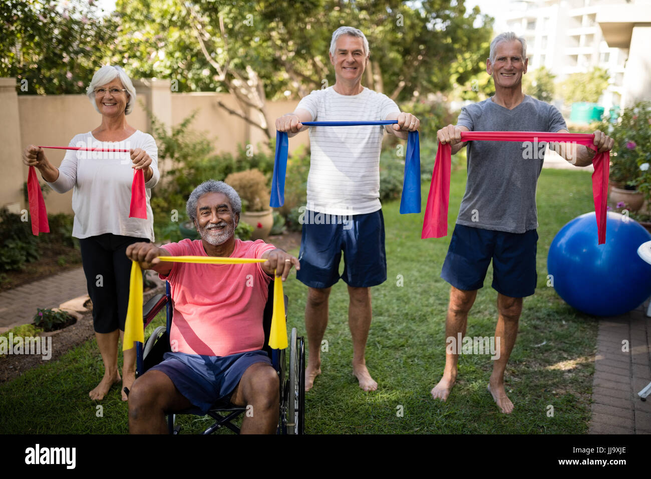 Porträt von älteres Paar halten Multi farbige Bänder während des Trainings im park Stockfoto