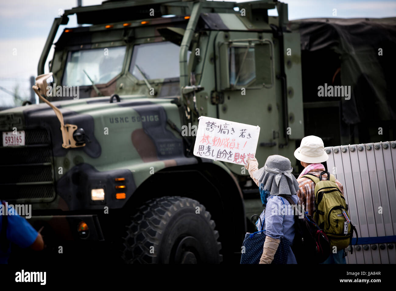 OKINAWA, JAPAN - 13 Juli: Anti-US-base Demonstranten mit Plakat versuchen, blockieren, US marine-Fahrzeug vor dem Camp Schwab-Tor zum protest gegen den Bau des neuen US-Marine base am 13. Juli 2017 in Henoko, Nago, Okinawa Präfektur, Japan. Demonstranten skandierten Parolen gegen die Pläne und Plakate prangerte die militärische Präsenz der USA, wie sie die Straße nach der Marine base in Henoko ausgekleidet statt. Bildnachweis: Richard Atrero de Guzman/AFLO/Alamy Live News Stockfoto