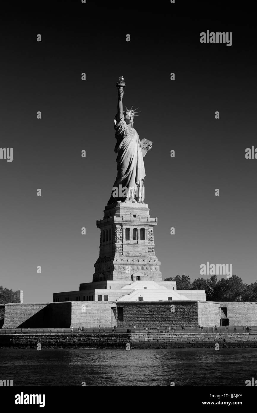 Freiheitsstatue und Liberty Island an einem sonnigen Tag, New York in schwarz / weiß Stockfoto