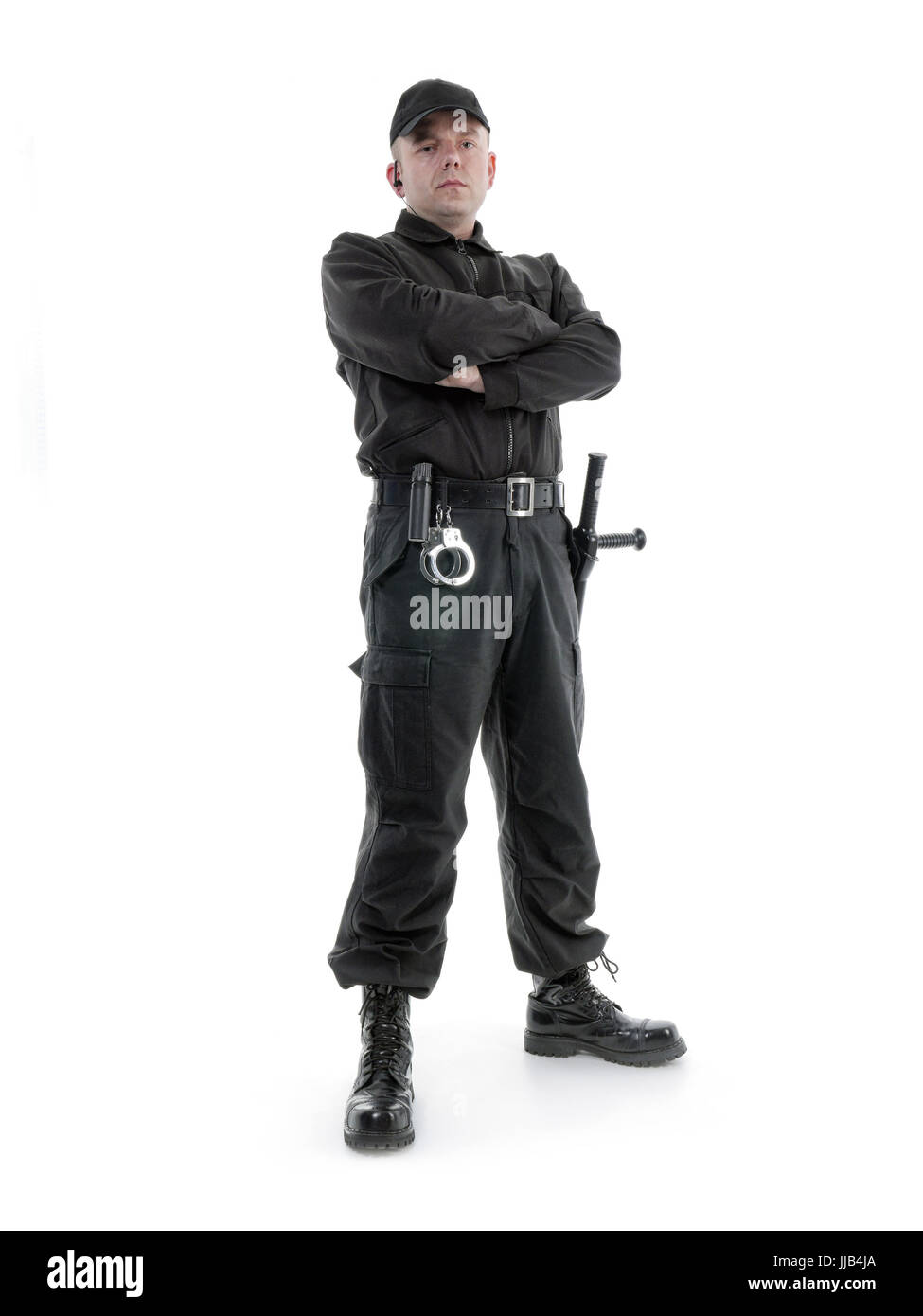 Security-Mann in schwarzer uniform geschossen ausgestattet mit Polizei-Club und Handschellen selbstbewusst, stehend auf weiß Stockfoto