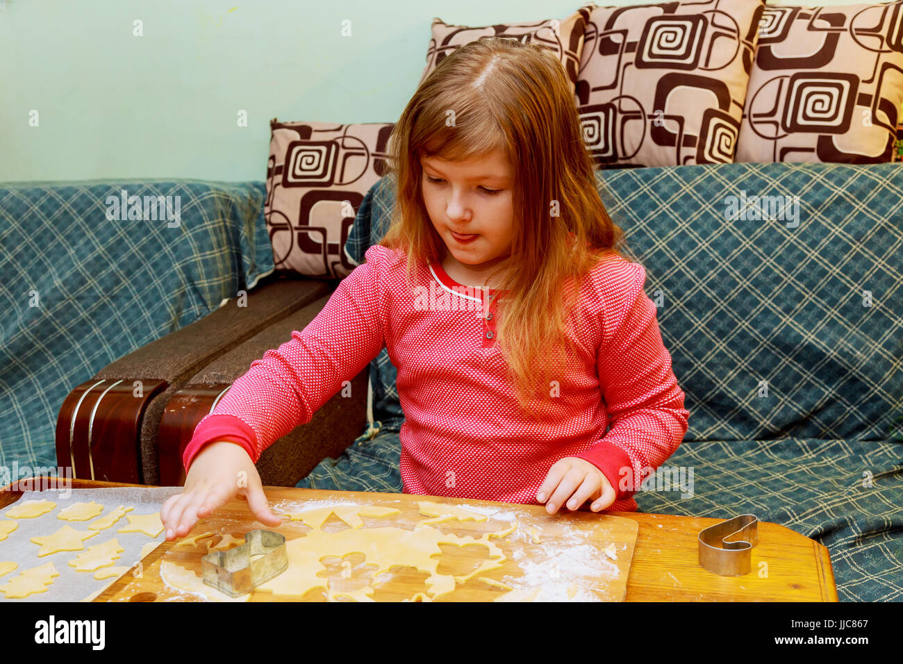 glückliches Mädchen mit Down-Syndrom backt cookies Stockfoto
