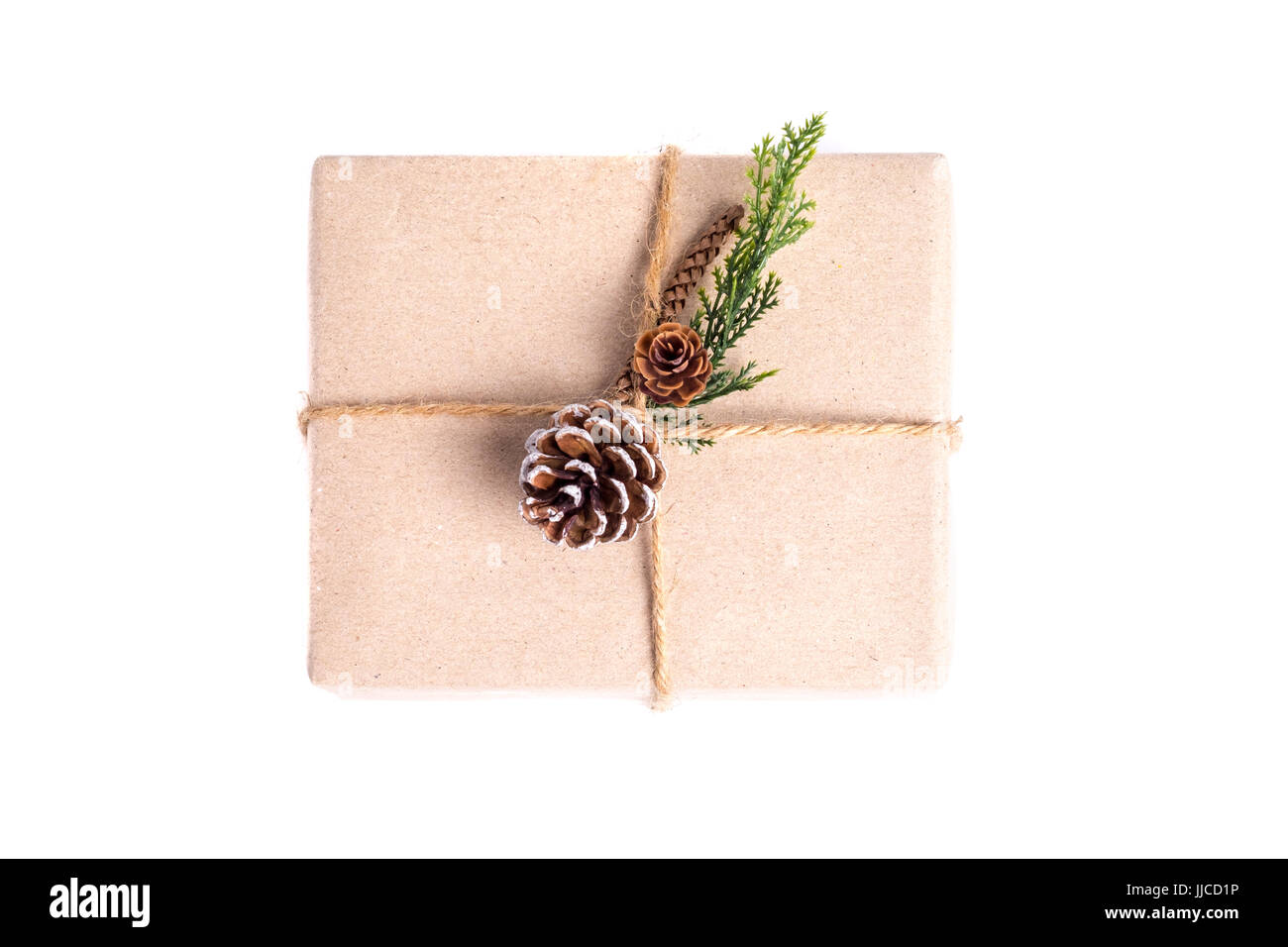 Braune Papier Handwerk verzogen auf Geschenkbox dekorieren mit Tannenzapfen und grünes Blatt isoliert auf weißem Hintergrund, Geschenke für saisonale Ferienkonzept. Stockfoto