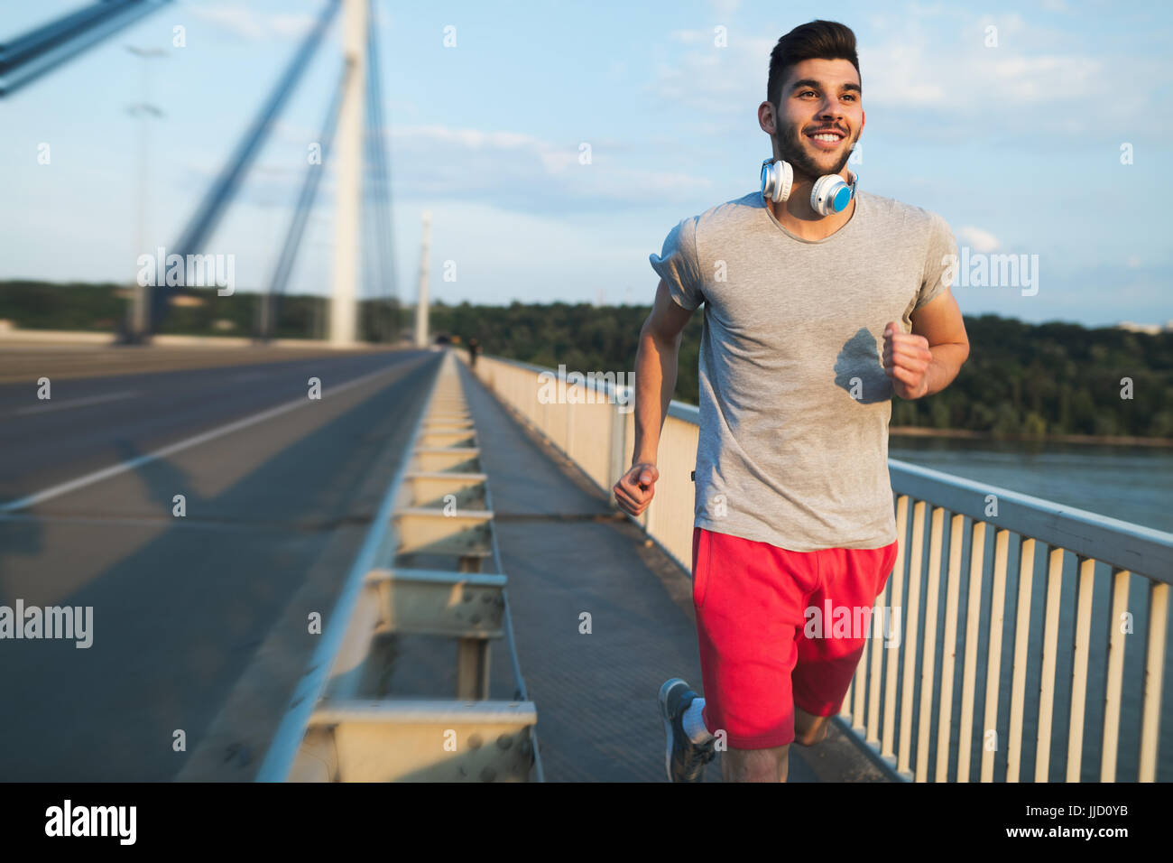 Porträt von gutaussehenden Mann läuft auf Brücke Stockfoto