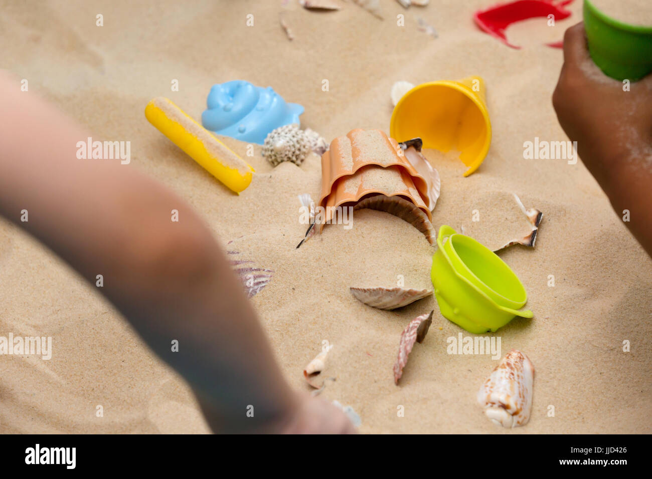 Kleine Hände erkunden den Strandsand Stockfoto