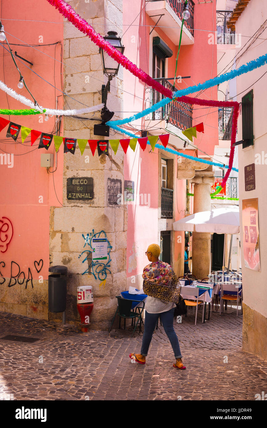 Lissabon Alfama Tourist, Rückansicht einer jungen Frau, die in einer bunten Straße in der Altstadt Alfama von Lissabon, Portugal, läuft. Stockfoto