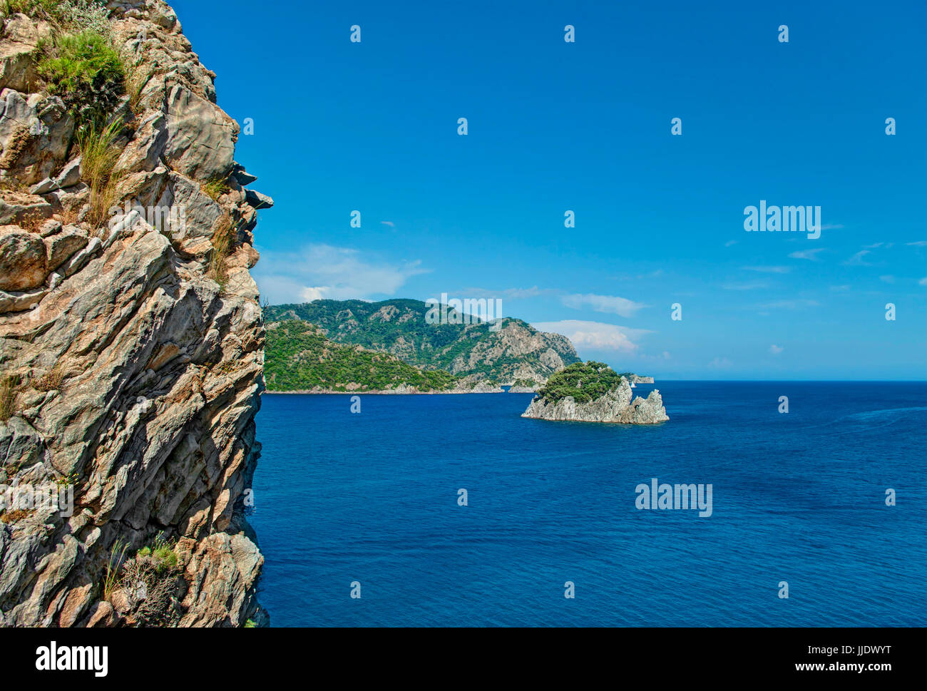 Blick auf die Ägäis und bergige Inseln mit Felsen im Vordergrund vor klaren blauen Himmel an sonnigen Tag in der Nähe Icmeler, Marmaris, Provinz Mugla, T Stockfoto