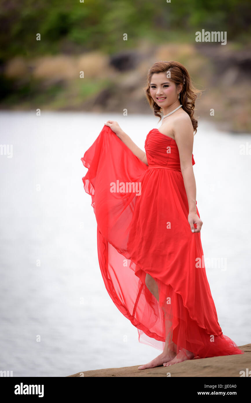 Schöne Frau tragen rote Abendkleid genießen auf dem Berg. Stockfoto