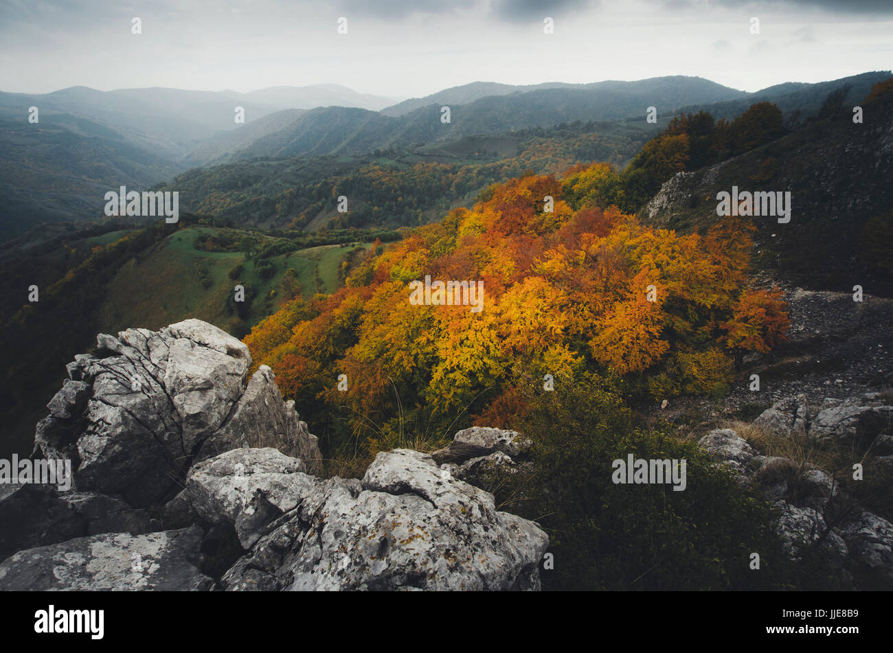 herbstliche Landschaft mit Hügeln, Bergen und Bäumen mit bunten Laub Stockfoto