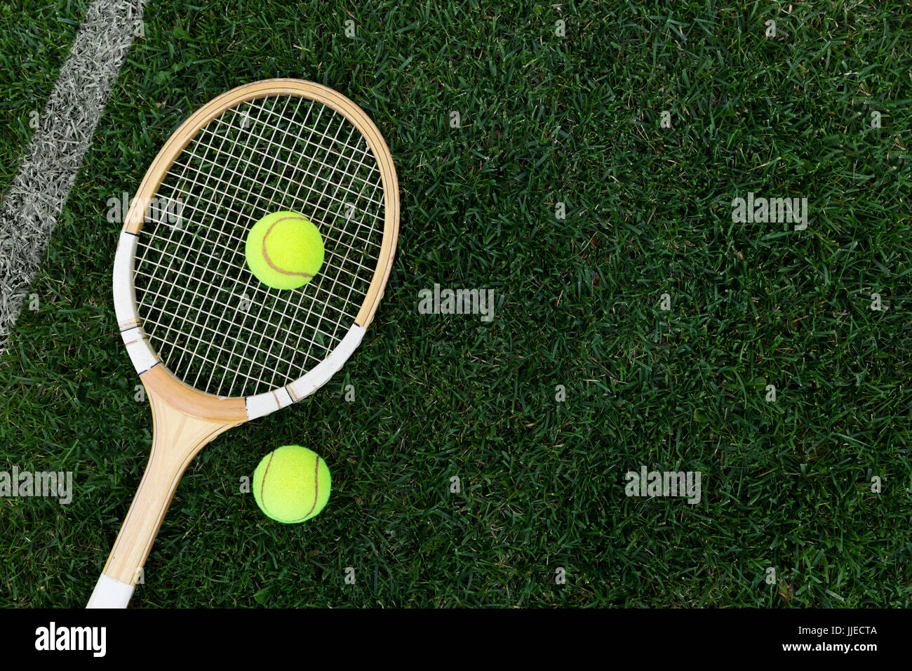 Retro-Tennisschläger auf Naturrasen mit Kugeln. Draufsicht mit Textfreiraum Stockfoto