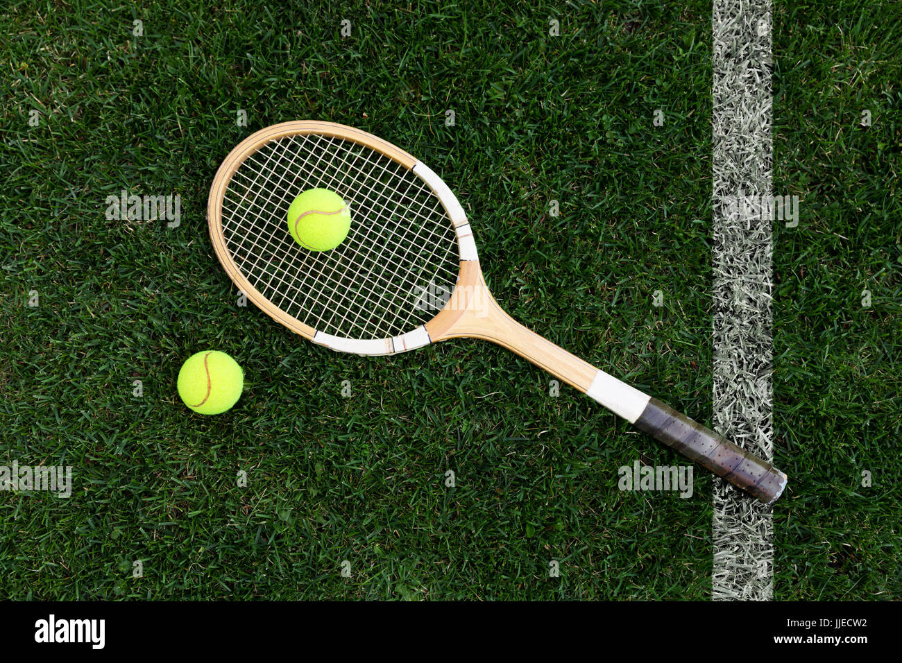 Retro-Tennisschläger auf Naturrasen mit Kugeln. Ansicht von oben Stockfoto