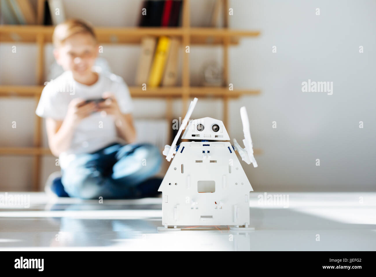 Blonder Junge genießt sein neues Spielzeug Roboter Stockfoto