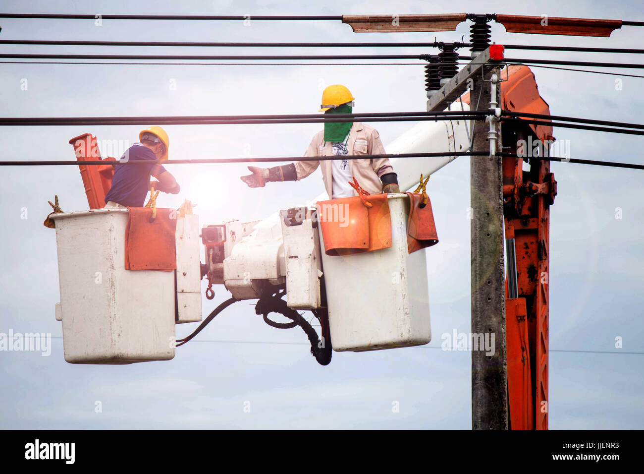 Hotline, Elektriker Kletterstange, ein Elektriker repariert ein Drahtsystem an einem elektrischen Mast, sehr gefährlich., Männer arbeiten Stockfoto