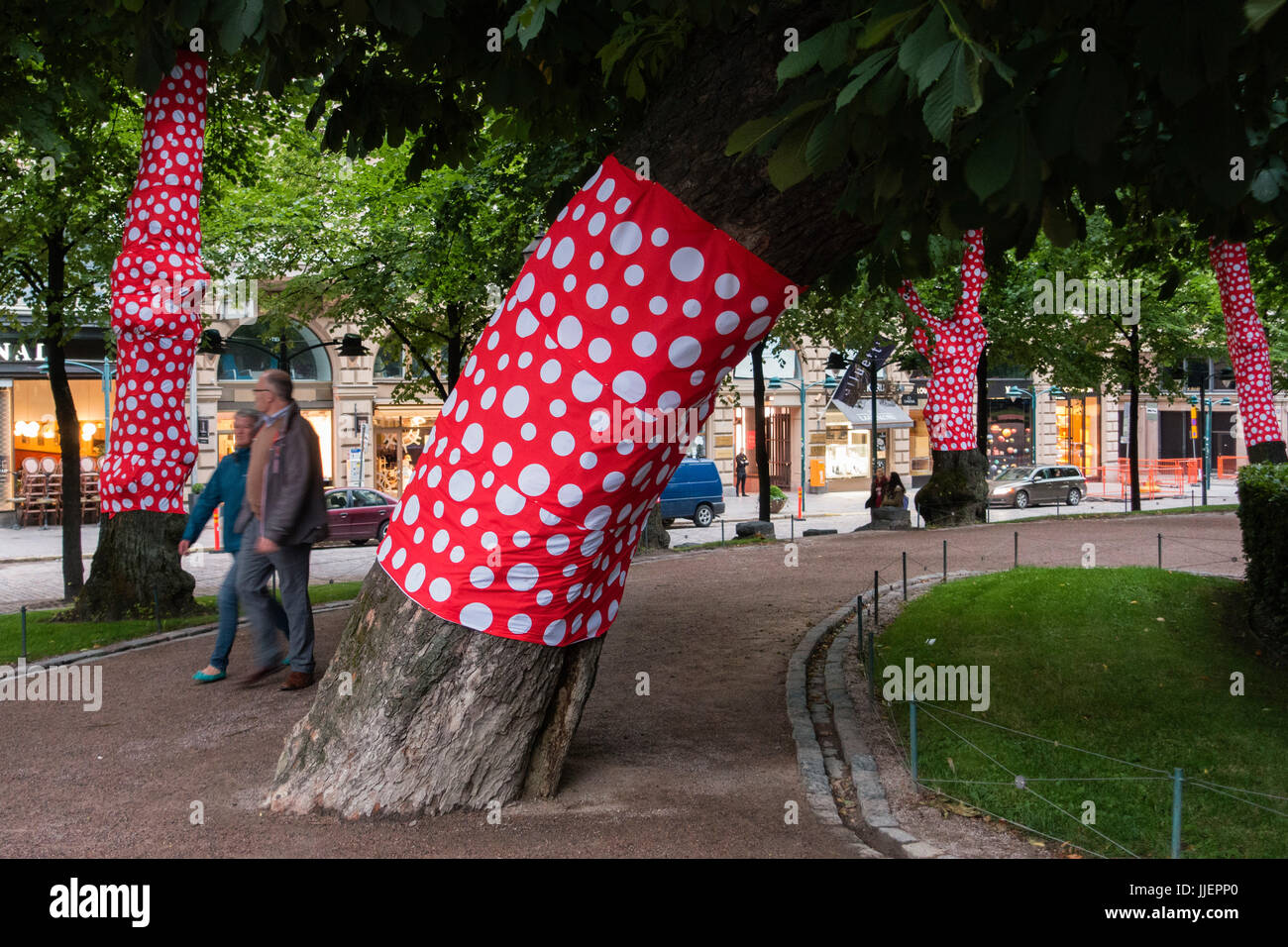 Dekorative rote Tarps, mit großen weißen Tupfen wickeln die Baumstämme in Esplanad Park im Stadtzentrum von Helsinki, Finnland. Stockfoto