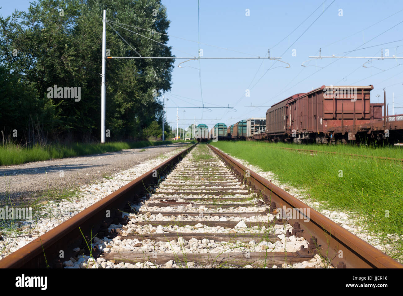 Schließen Sie schmale Schuss aus einem Zug Holz und Metall zu verfolgen, bei der italienischen Bahn-Depot in Bologna in der Nähe eines Güterzuges Stockfoto