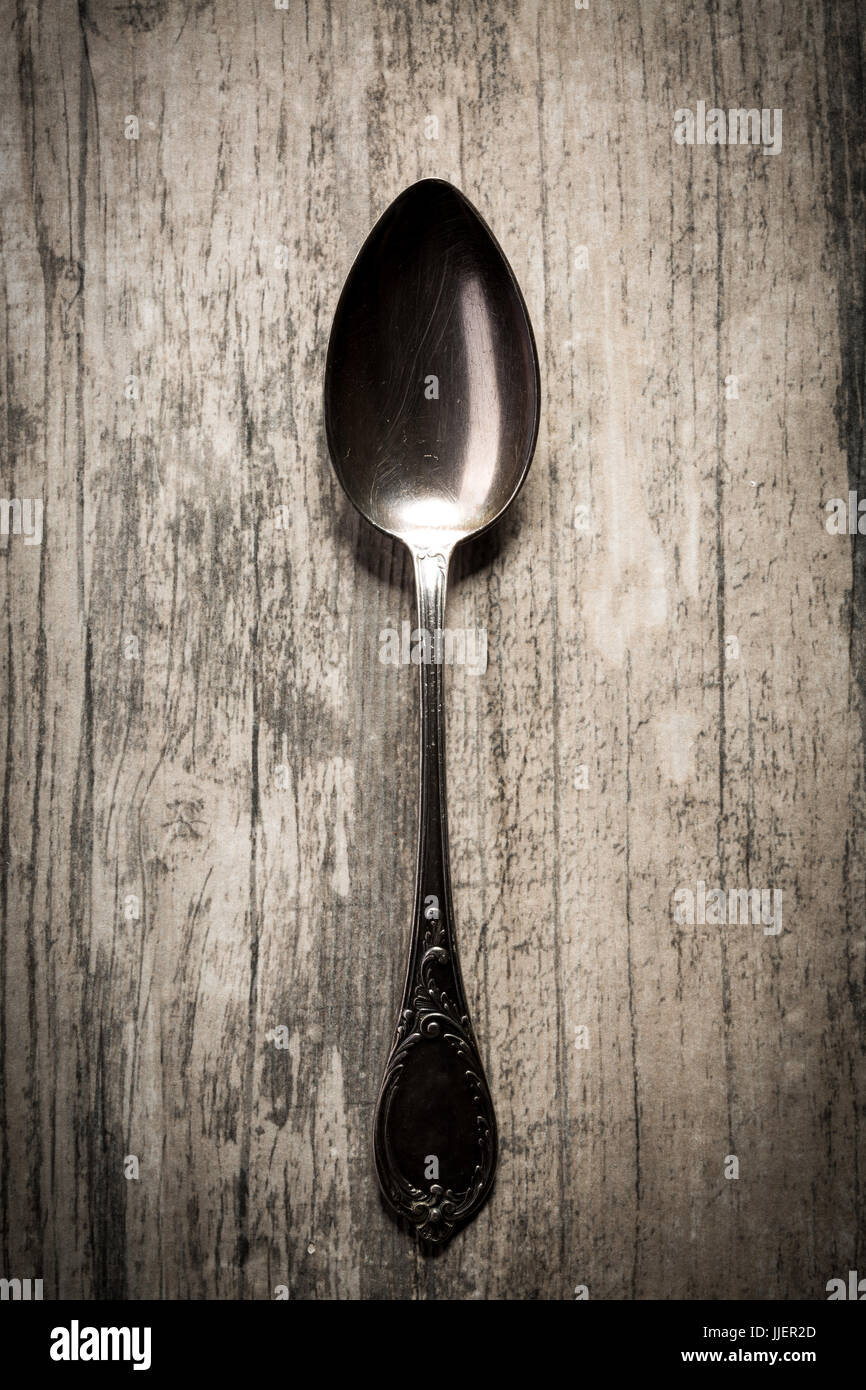 Alte antike Löffel auf dunklem Holz. Stockfoto