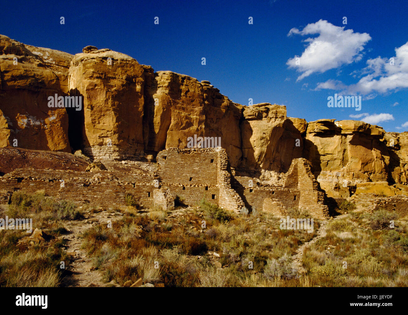 Sandstein gemauerte Wände von Ungarisch Pavi Pueblo, Chaco Canyon in New Mexico mit Sandstein von North Mesa nach hinten. Ein mehrstöckiges Anasazi grosses Haus Stockfoto