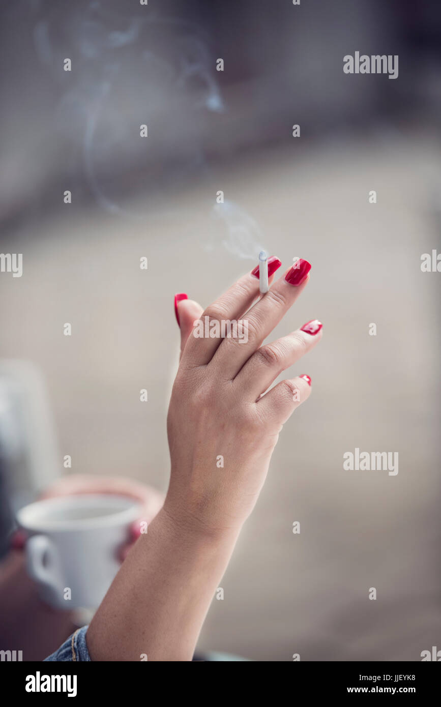 Frau Tasse Kaffee trinken und Rauchen eine Zigarette Stockfoto